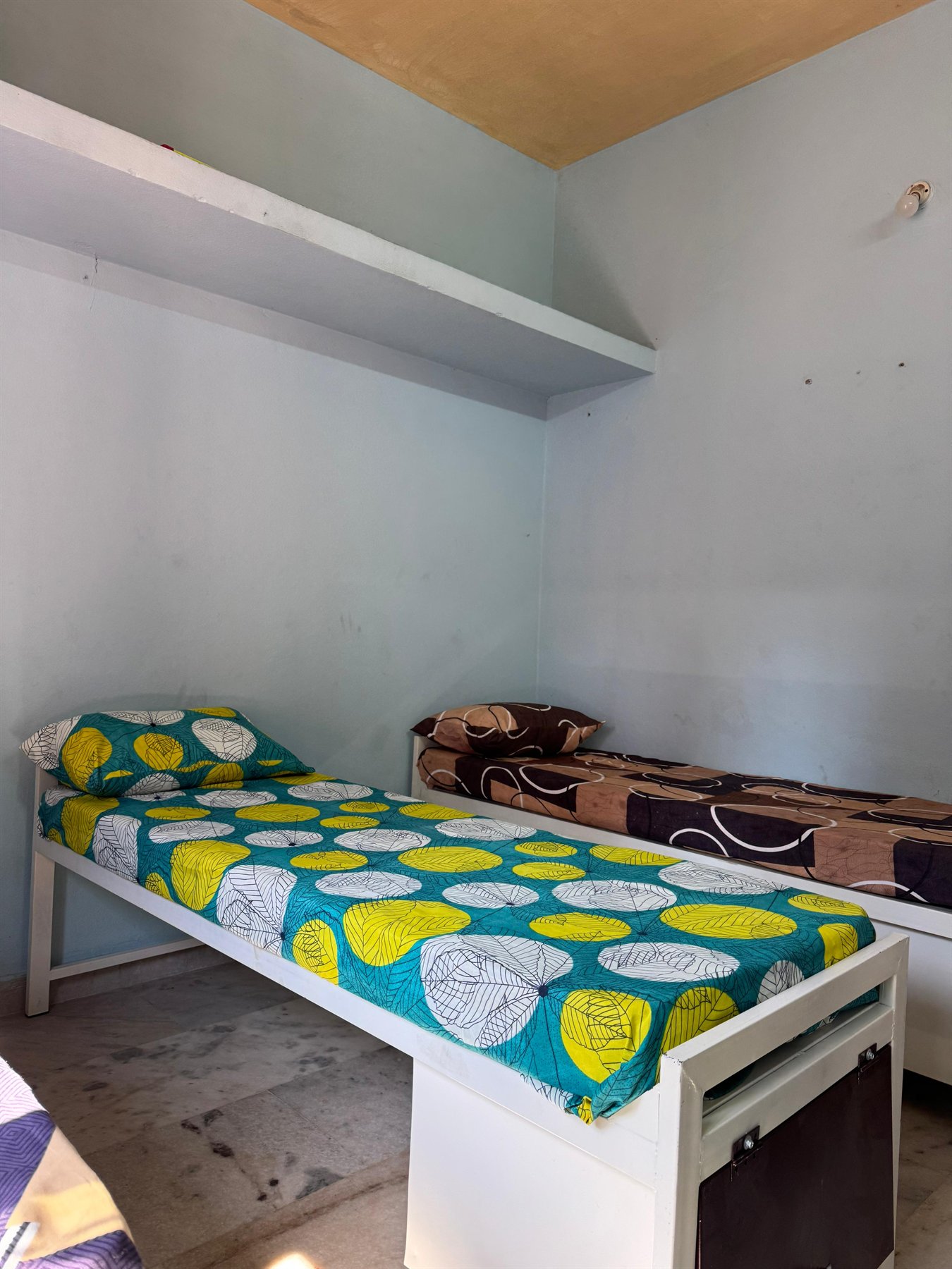Boys hostel portrait room view with bed and storage